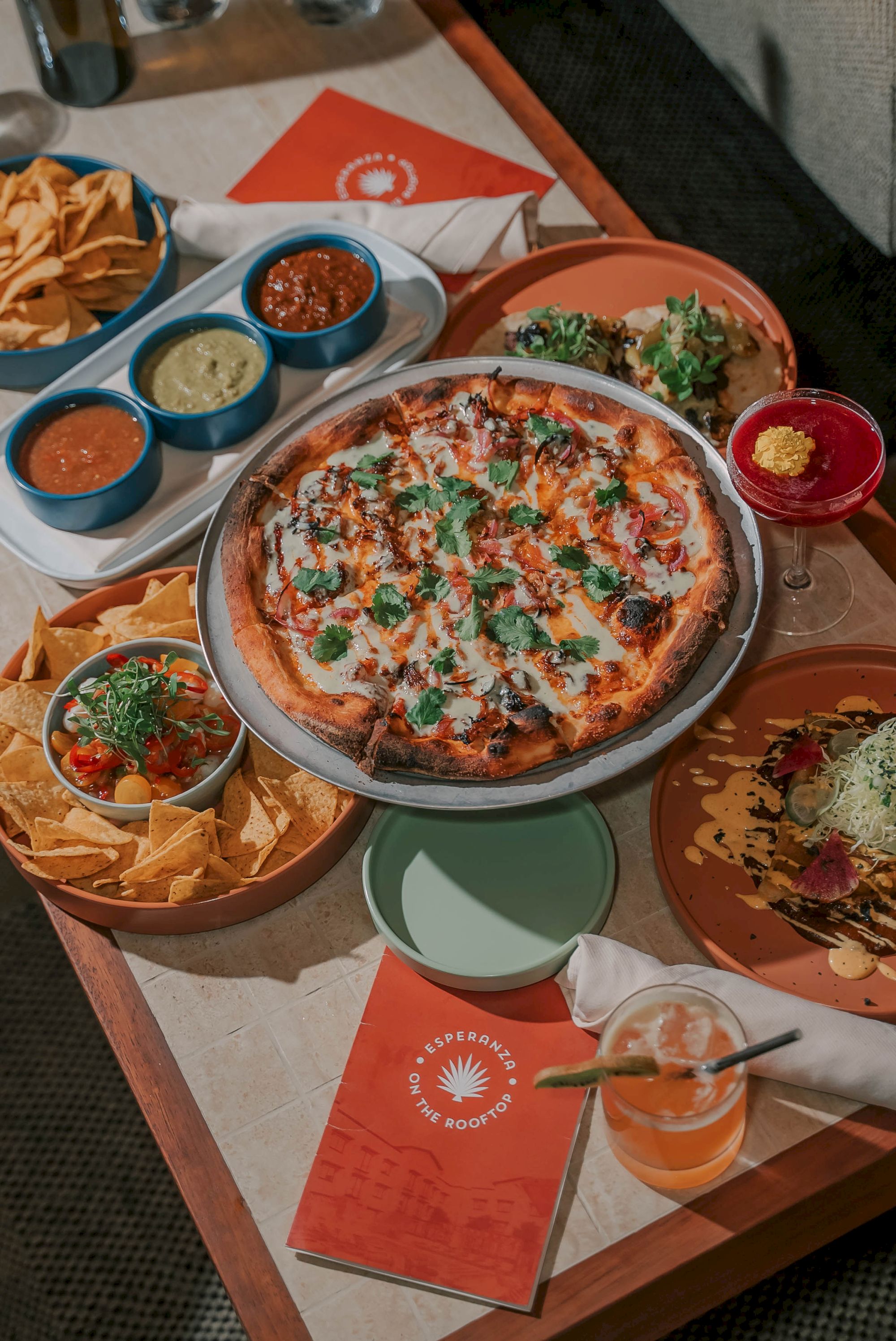 The image shows a spacious, modern lounge with ample seating, warm lighting, and wooden beams, creating a cozy atmosphere.